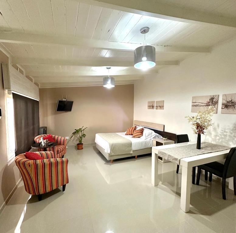 Un dormitorio con una cama y una mesa y sillas. en Apartamento de las Araucarias, en Esquel