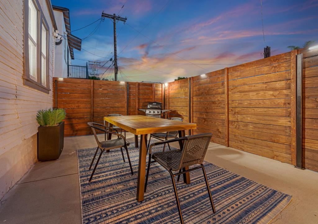a patio with a wooden fence and a table and chairs at Chic Oasis Studio: Minutes to Downtown & Beaches in National City