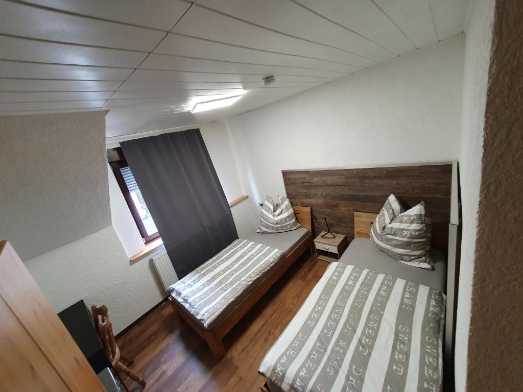 Habitación con 2 camas y ventana en Hotel Restaurant TAPASTA, en Neuwied