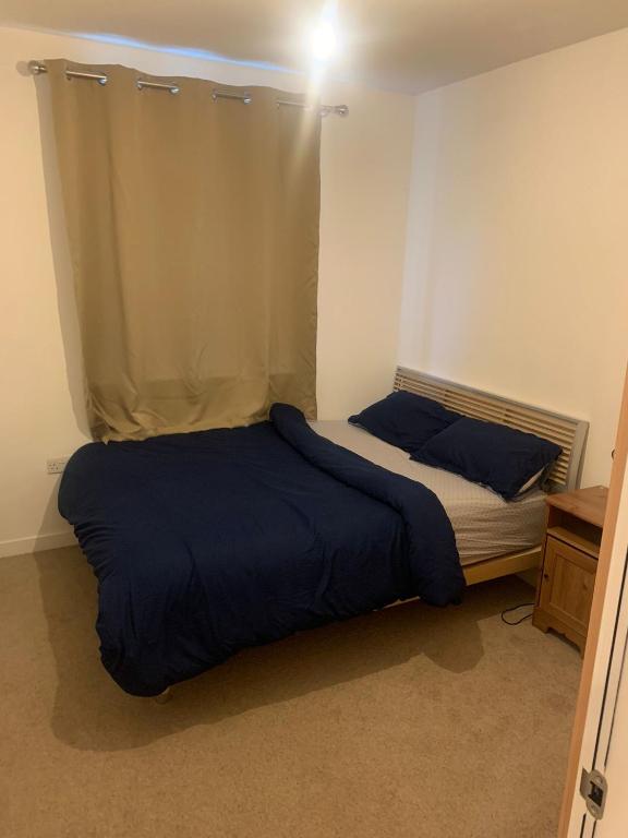 2SWEETZ HOME 2 في Erith: غرفة نوم بسريرين مع وسائد زرقاء