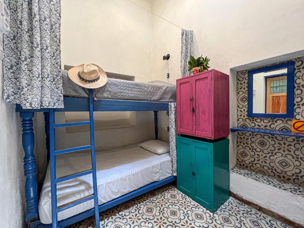 a bunk bed with a hat on top of it at Hostel Candelaria in Valladolid