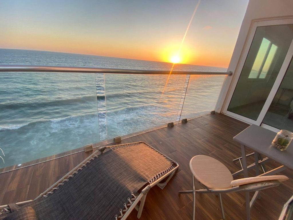 a balcony with a view of the ocean at sunset at Lovely 2 bedroom oceanfront condo in Mazatlan in Mazatlán