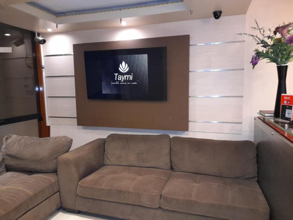 a living room with a couch and a television at hotel taymi in Trujillo