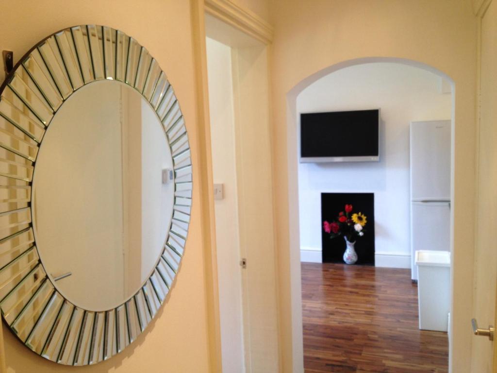 a mirror on the wall of a room with a hallway at Caledonian Apartments in Edinburgh