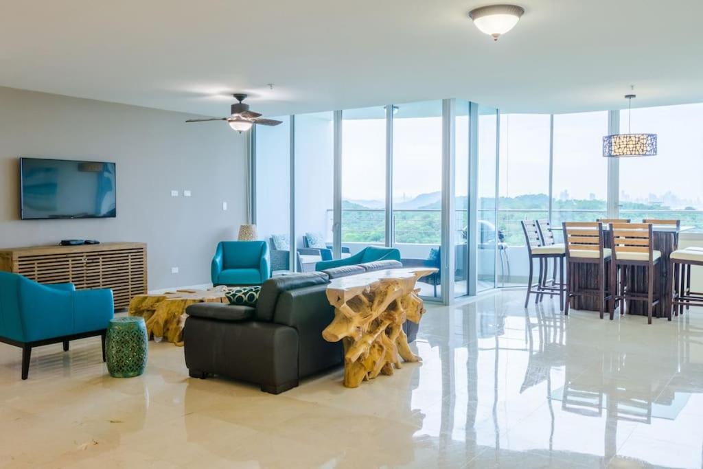 a living room with a couch and a table and chairs at 23o Penthouse Stunning Oceanview Resort Lifestyle in ArraijÃ¡n