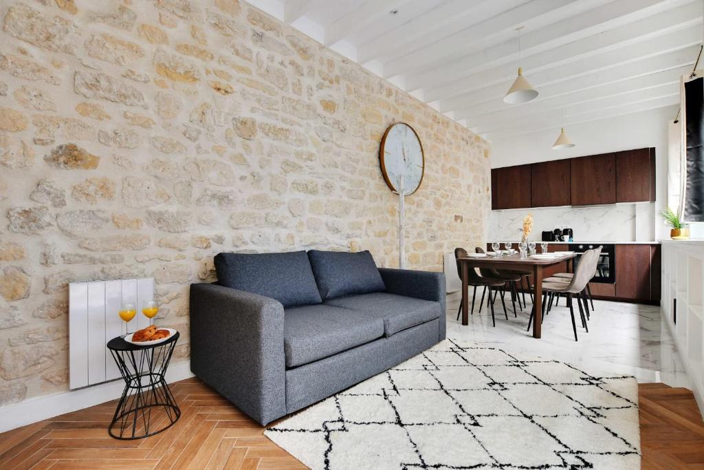 a living room with a couch and a table at Very nice triplex apartment bright in Montorgueil in Paris