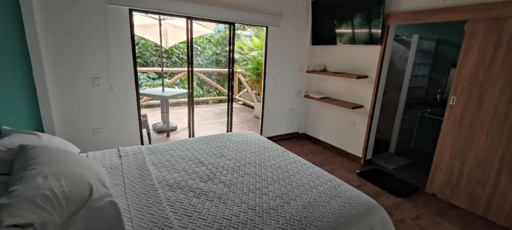 1 dormitorio con cama y vistas a un balcón en Minka Paradise, en Minca
