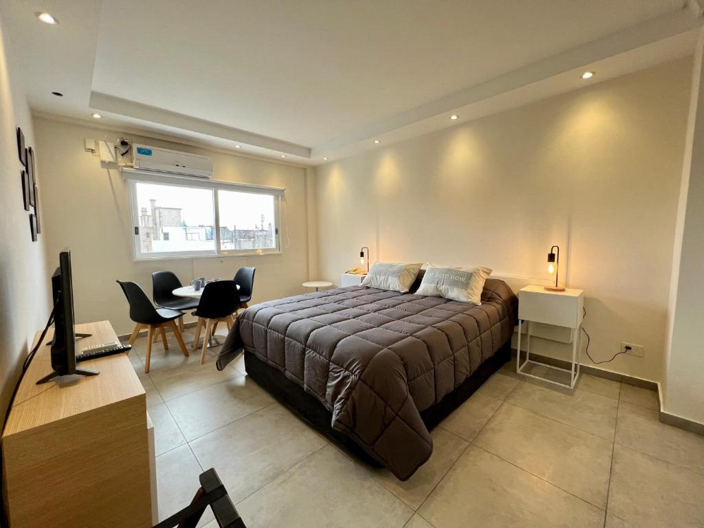 1 dormitorio con 1 cama, mesa y sillas en Selbard Suite en Buenos Aires