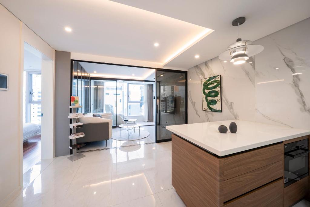 a kitchen with a counter and a living room at UH FLAT The Seocho in Seoul