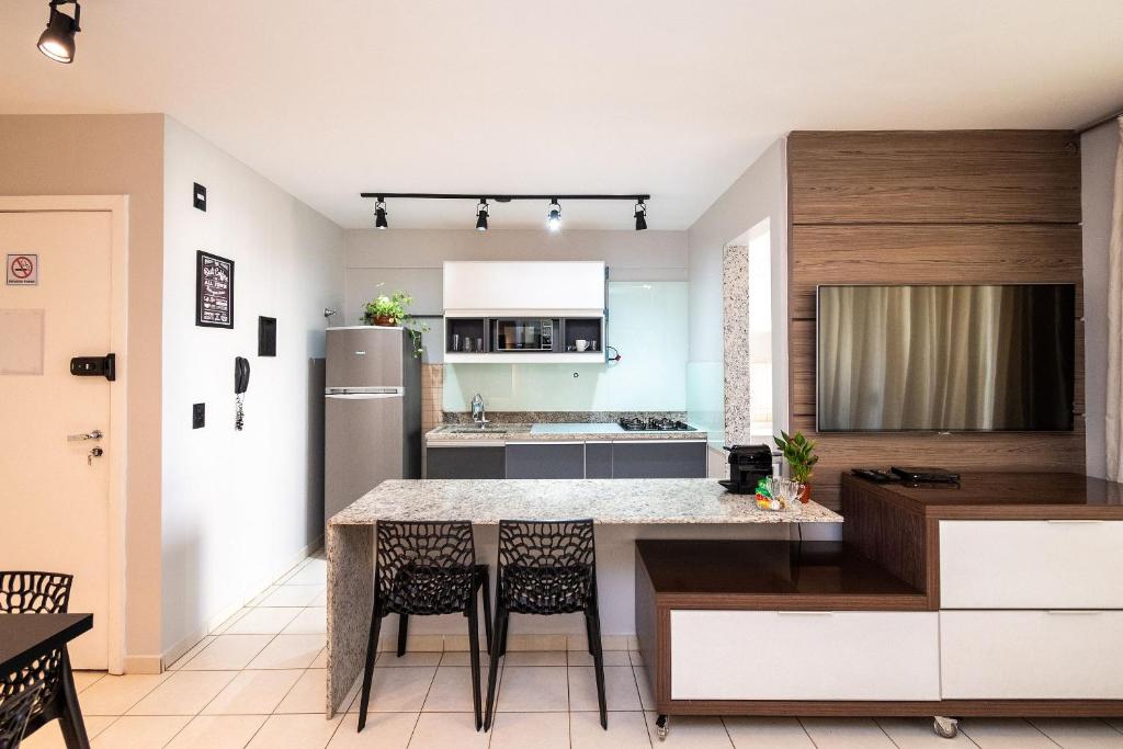 uma cozinha com uma mesa e cadeiras e um frigorífico em Tranquilidade e Conforto próximo ao Flamboyant em Goiânia