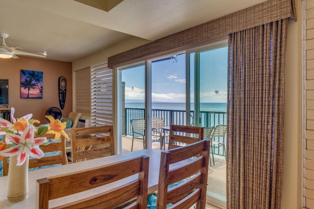 a dining room with a view of the ocean at Maui Sands #5G in Kahana