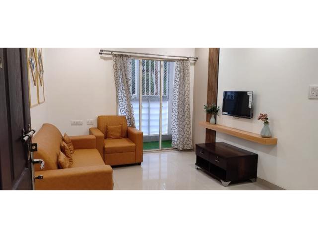 uma sala de estar com dois sofás e uma televisão em B S Homes em Hyderabad