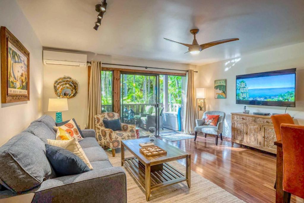 a living room with a couch and a tv at Tropical & Serene Ground Floor in Kihei