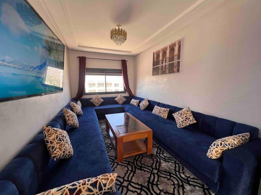 a living room with a blue couch and a table at Beachfront surfers paradise in Aourir