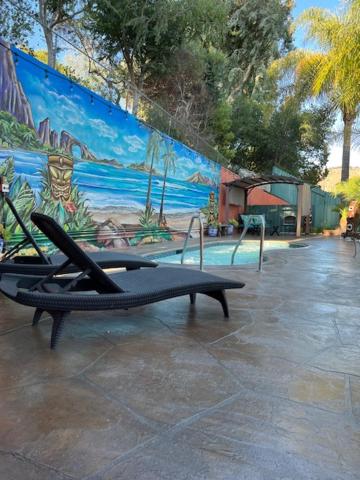 a bench in front of a pool with a mural at Oakridge Inn in Oak View