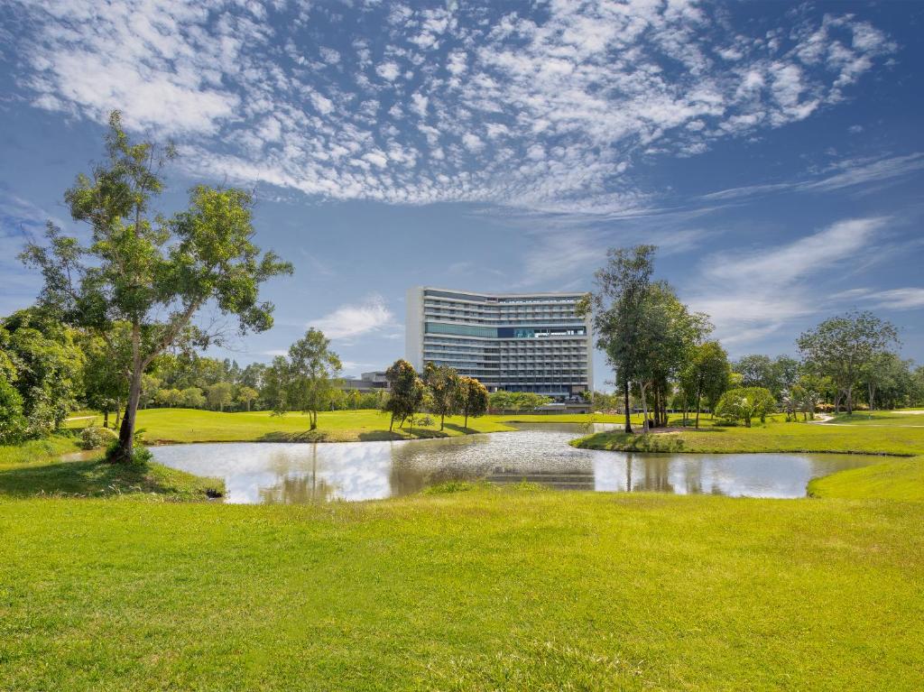 a pond in a park with a building in the background at Radisson Golf & Convention Center Batam in Batam Center
