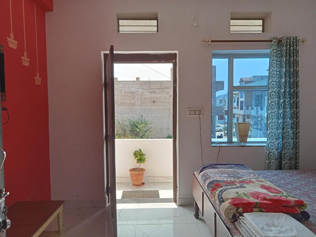 1 dormitorio con 1 cama y puerta de cristal con ventana en Cocoon Auberge en Jaipur