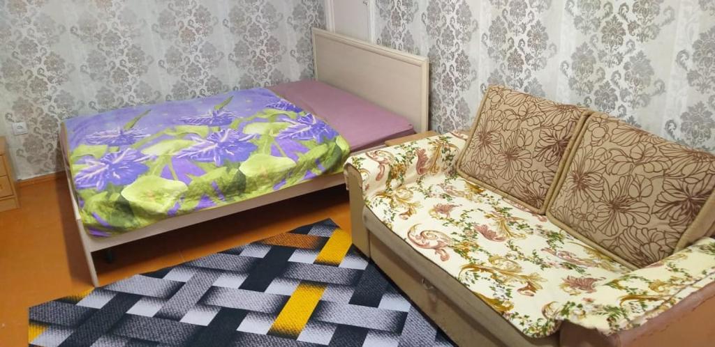 1 Schlafzimmer mit 2 Betten, einem Sofa und einem Teppich in der Unterkunft Аренда квартир Балхаш in Balqasch