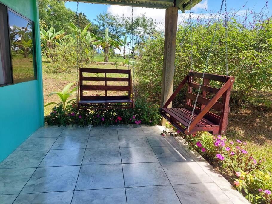 - deux bancs en bois assis sur une terrasse fleurie dans l'établissement Casita Los Guarumos (Finca Las Colinas), à Bijagua