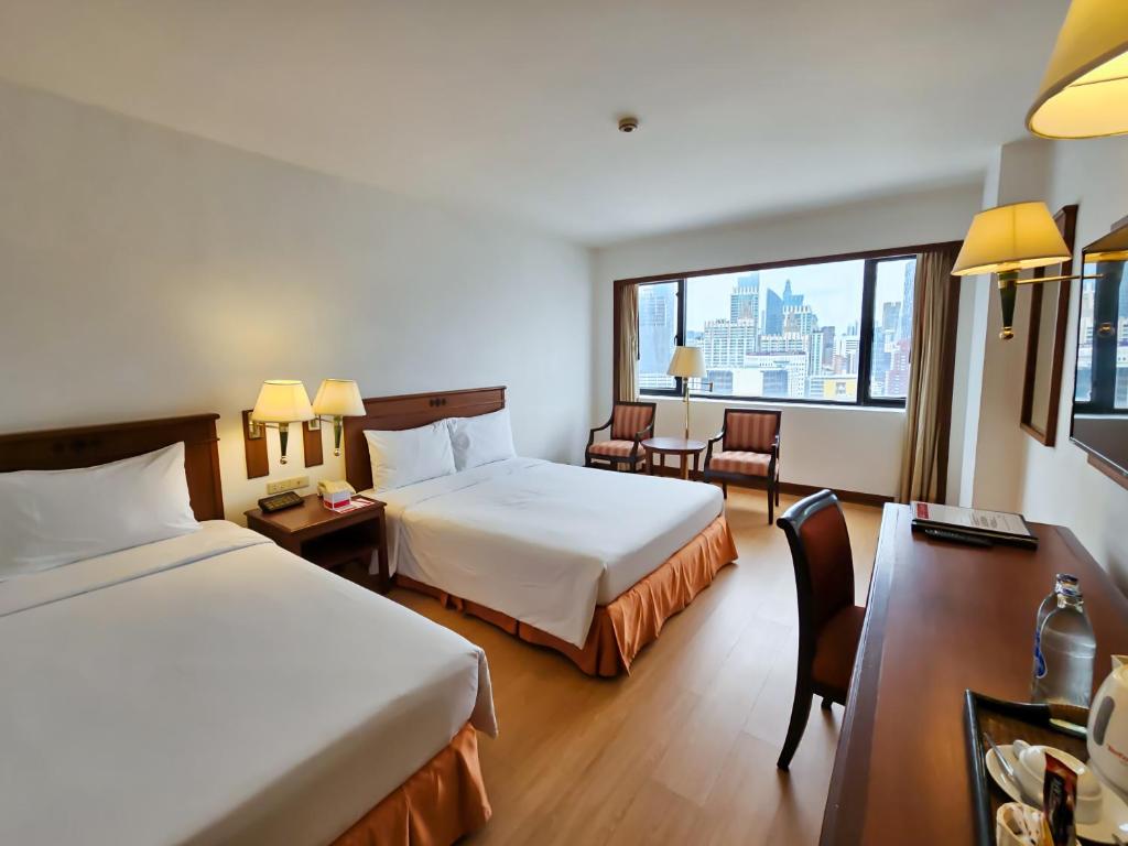 een hotelkamer met 2 bedden en een raam bij Ramada by Wyndham D MA Bangkok in Bangkok