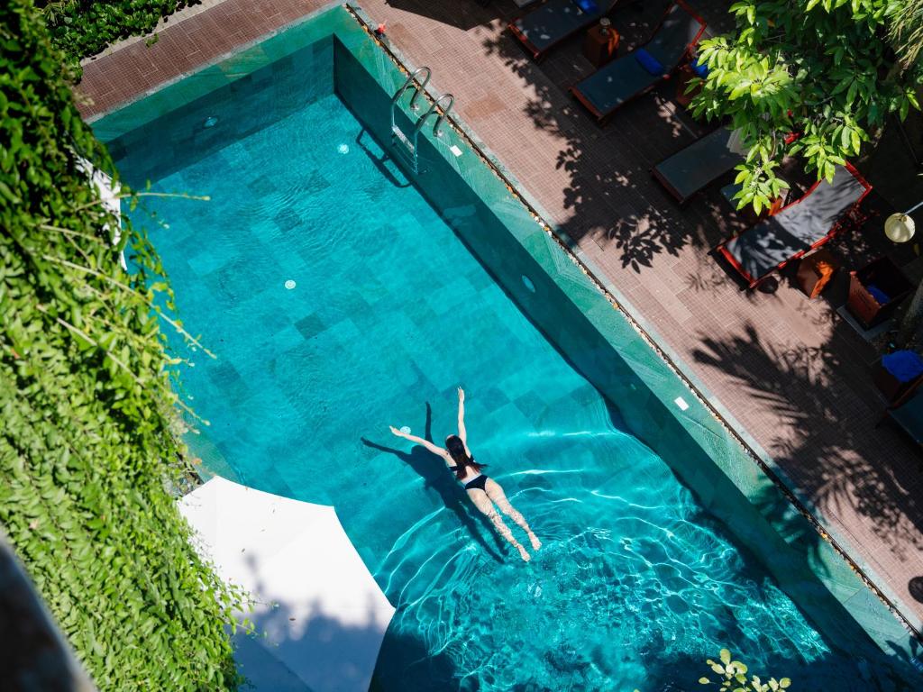uma pessoa a nadar numa piscina na água em Mulberry Collection Silk Eco em Hoi An