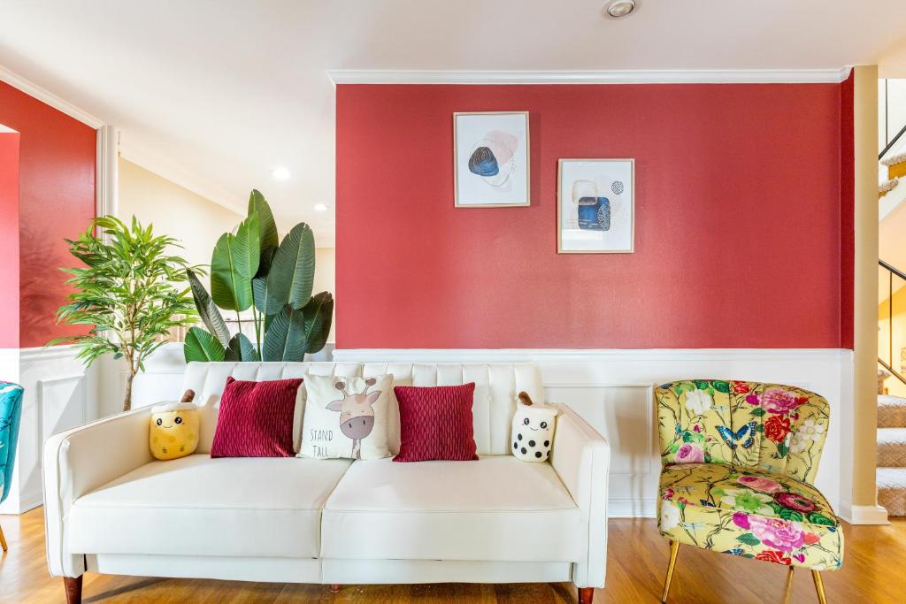 a living room with a white couch and a red wall at Beautiful & Large Townhouse in Downtown Arlington Near DC in Arlington