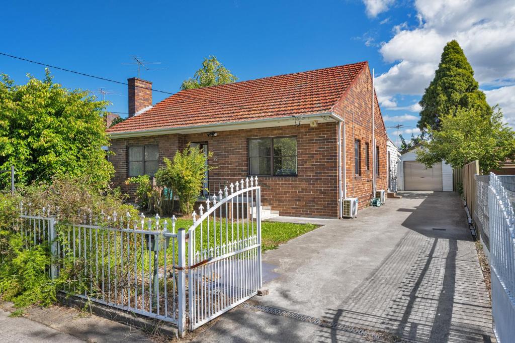 een stenen huis met een poort en een oprit bij Belmore Brand new renovated 3Br house AC & Parking in Sydney