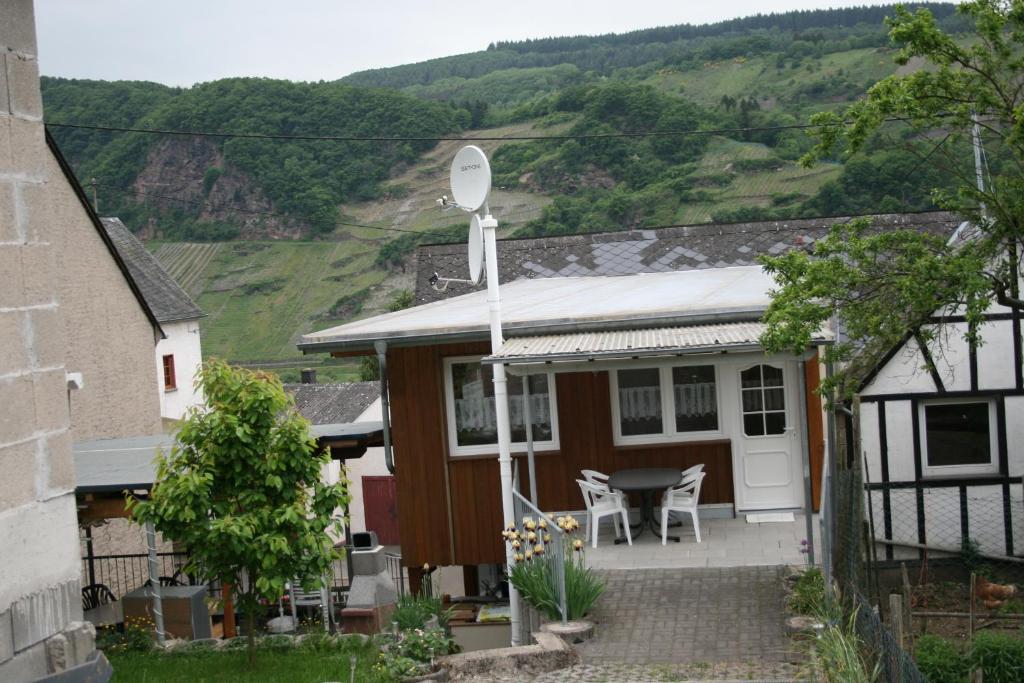 a house with a satellite with a table and chairs at Zwei Ferienwohnungen "Im Weingarten " in Burg (an der Mosel)