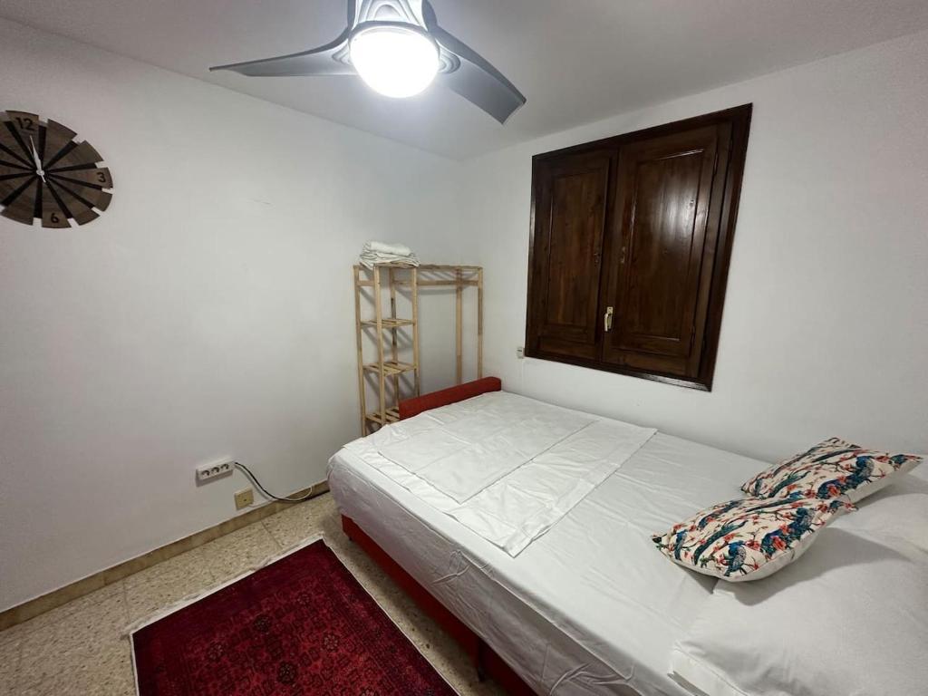 - une chambre avec un lit et un ventilateur de plafond dans l'établissement Can Ginesta Muy feliz&tranquilo, à Barcelone