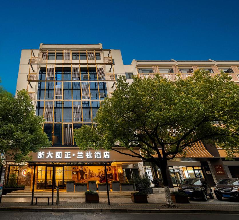 Un edificio alto con un cartel delante. en Hangzhou Lanshe hotel, en Hangzhou