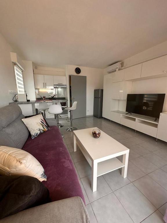 a living room with a couch and a table at Le Castello in Saint-Aygulf