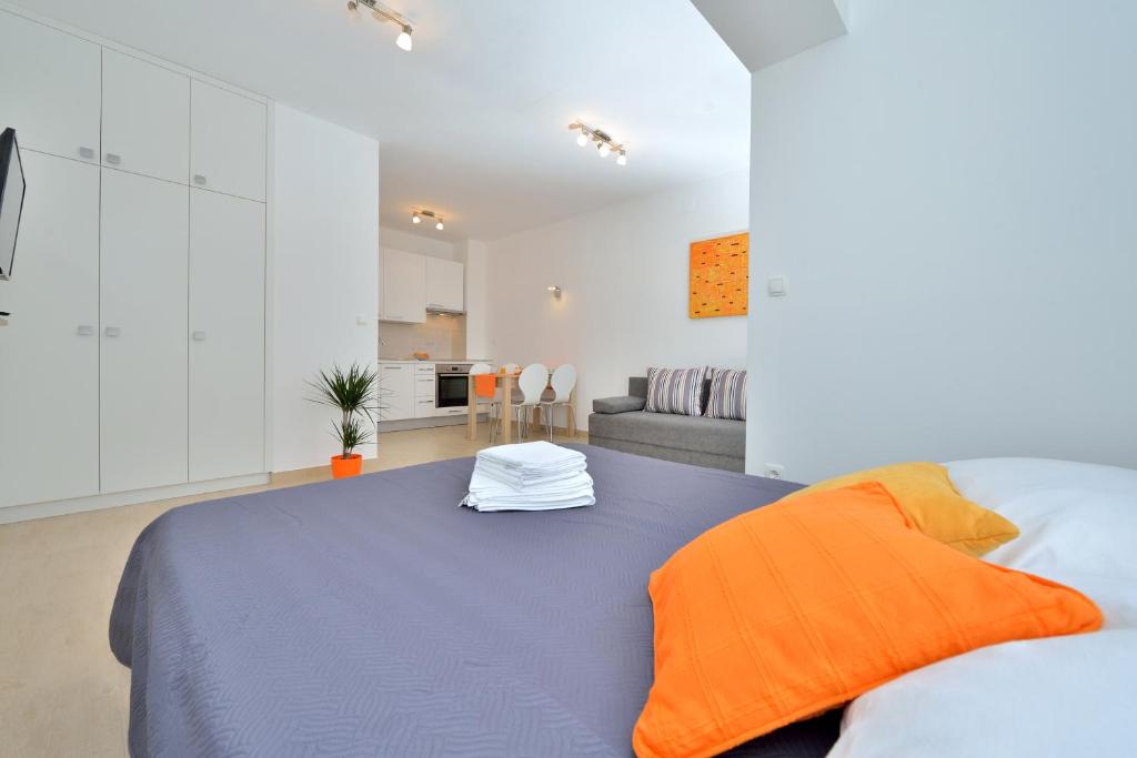 ein Schlafzimmer mit einem großen Bett mit orangefarbenen Kissen in der Unterkunft Apartment Stipić in Zadar
