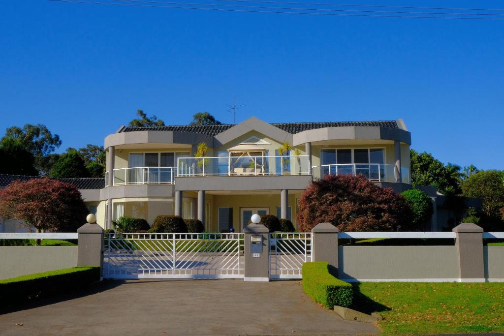 uma grande casa branca com uma cerca branca em Kellyville Luxury 5 Br House Quiet & Spacious em Kellyville