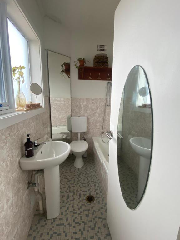 uma casa de banho com um lavatório, um WC e um espelho. em Ocean view em Sidney