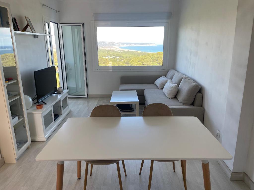 ein Wohnzimmer mit einem weißen Tisch und einem Sofa in der Unterkunft NUEVO. Reformado con vistas panorámicas y piscina in Pals