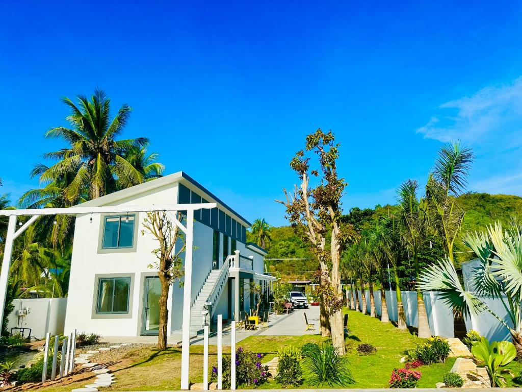 a row of houses on a street with palm trees at 24 Gold Homestay in Phan Thiet