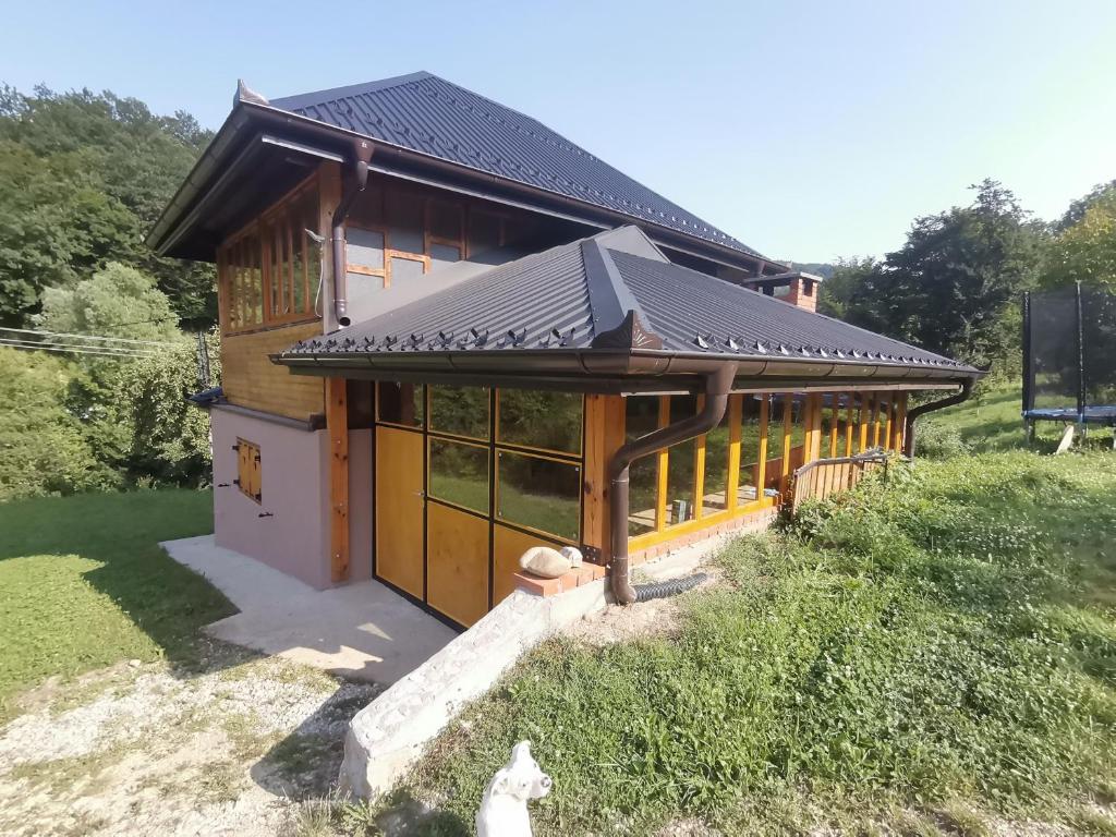 une petite maison avec un toit en métal. dans l'établissement Vikendica Jagodica, à Ivanjica