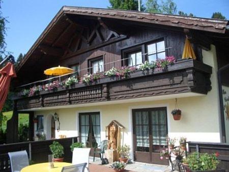 ein Haus mit einem Balkon mit Blumen darauf in der Unterkunft Haus Cornelia in Jungholz