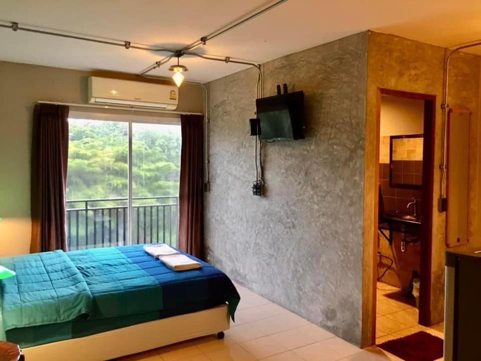 sypialnia z niebieskim łóżkiem i balkonem w obiekcie khaolak big bike&room for rent w mieście Khao Lak