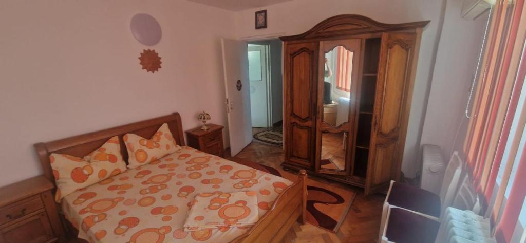 sypialnia z łóżkiem, komodą i lustrem w obiekcie Apartament Adrian w mieście Eforie Nord