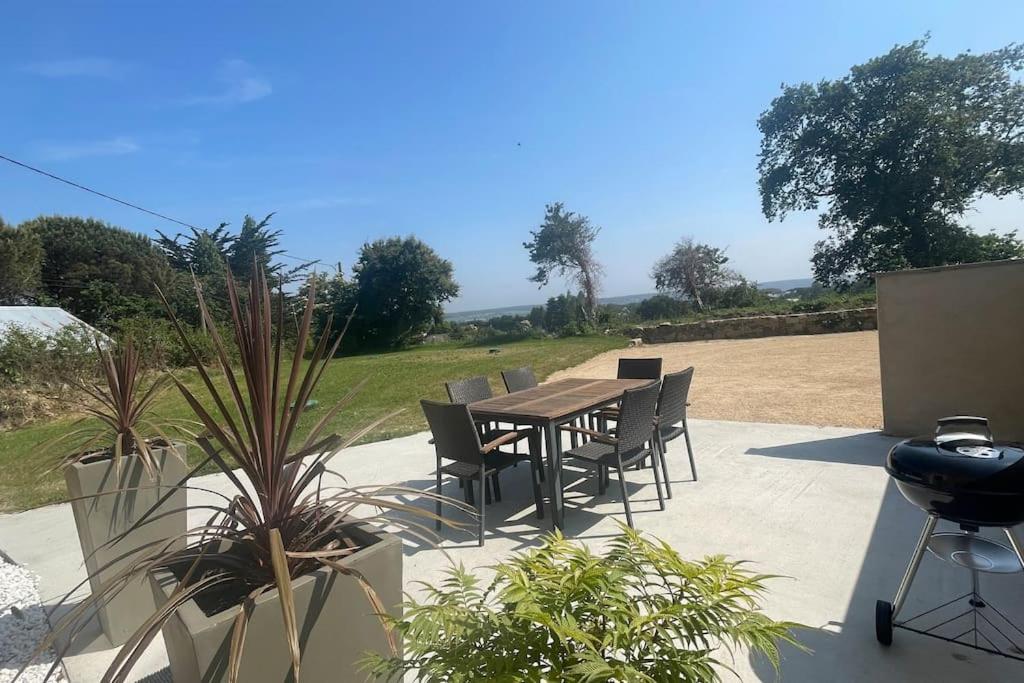a patio with a table and chairs and a grill at Maison bretonne - cottage in Lézardrieux