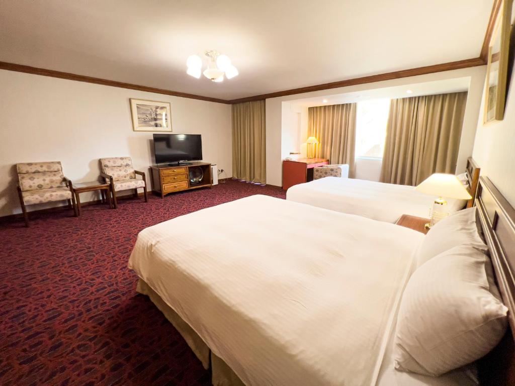 Postel nebo postele na pokoji v ubytování Hotel Tainan
