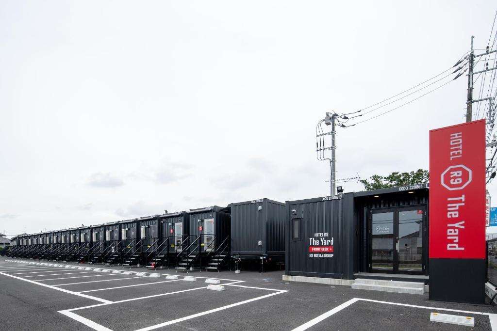 eine lange Reihe von Zugautos, die auf einem Parkplatz geparkt sind in der Unterkunft HOTEL R9 The Yard Hitachinakaichige in Hitachinaka