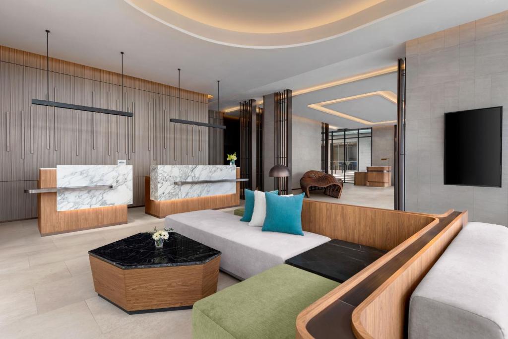 a living room with a couch and a tv at Courtyard by Marriott Bangkok Sukhumvit 20 in Bangkok