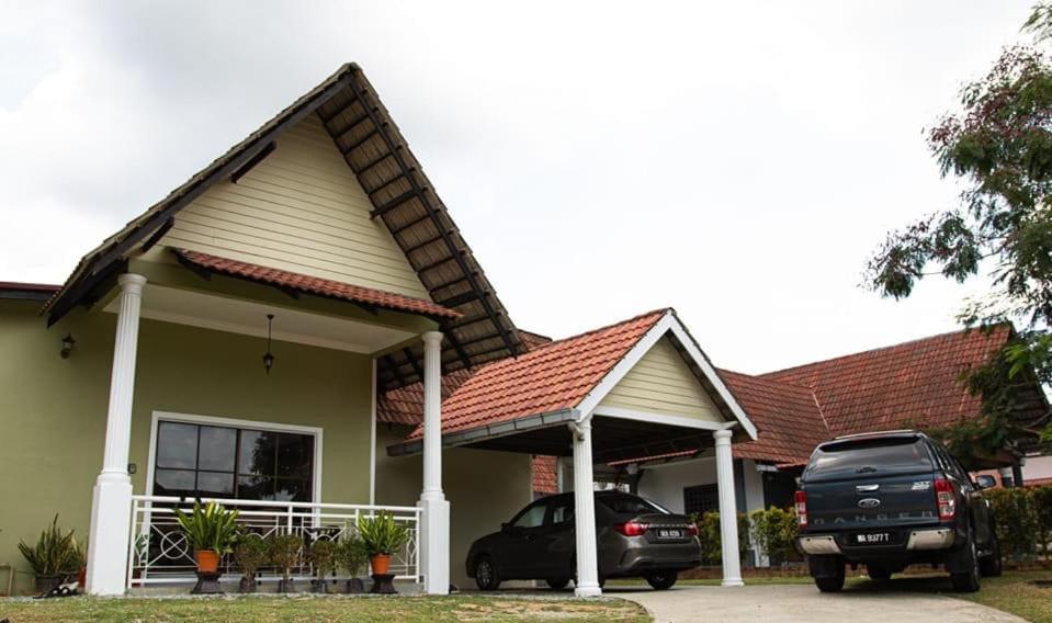 a car parked in front of a house at Poolhomestay Raudhah Intan in Kampong Alor Gajah