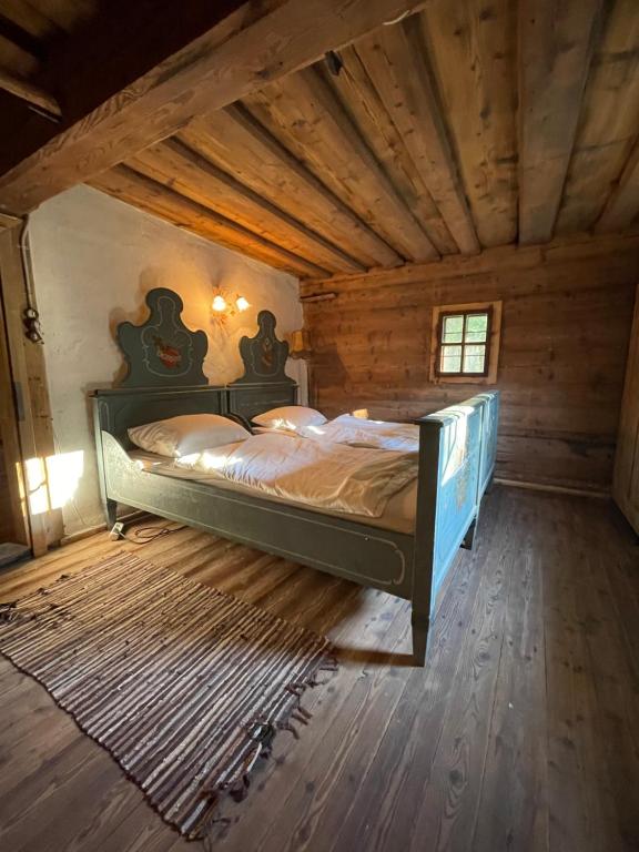 a bedroom with a bed in a wooden room at 200-Jahre altes Koschuta Bauernhaus 