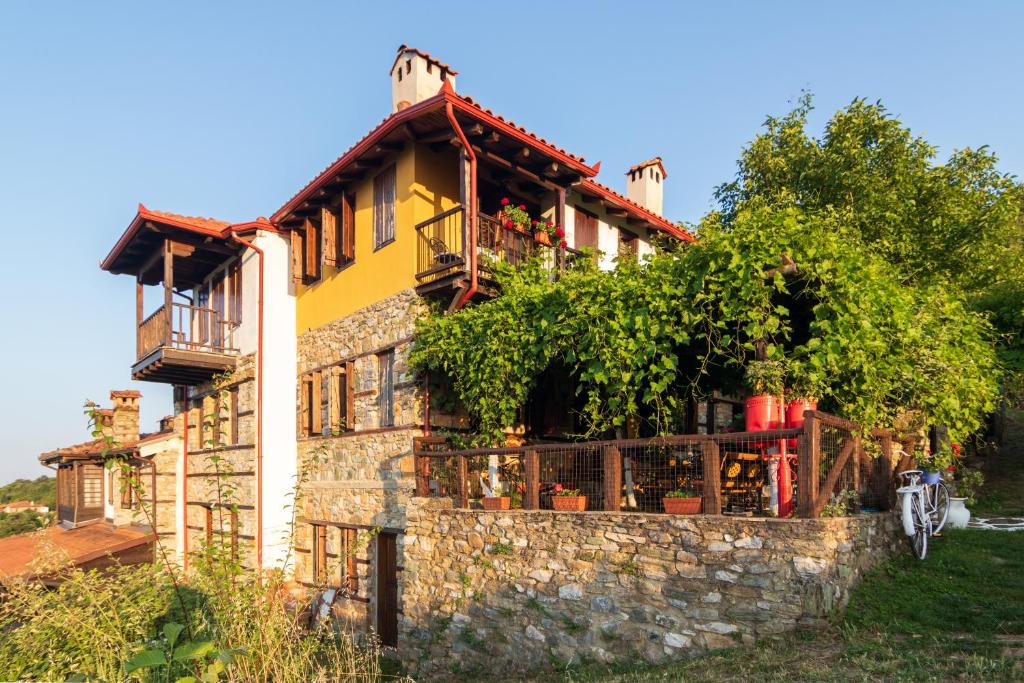 une maison sur un mur en pierre avec des plantes dans l'établissement Guesthouse Oneiro, à Palaios Panteleimonas