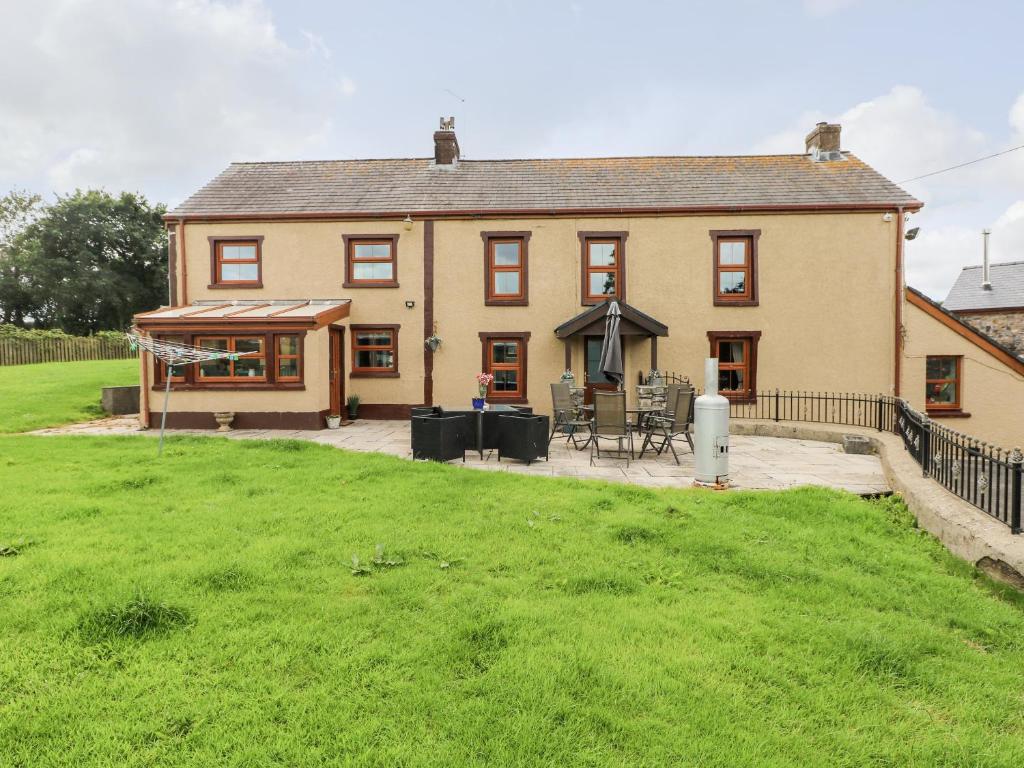 ein großes Haus mit Rasen davor in der Unterkunft Pant Teg Farm in Kidwelly