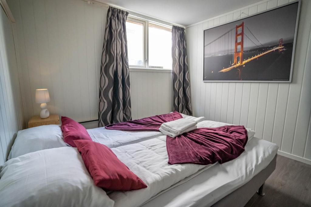 un lit avec des draps rouges et blancs et une fenêtre dans l'établissement Bnb Central Apartment 4Stavanger - Berti-2rooms, à Stavanger
