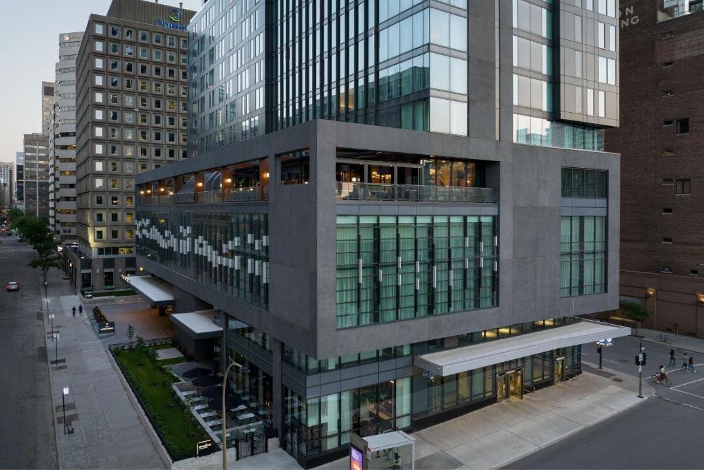um edifício alto com muitas janelas numa cidade em HONEYROSE Hotel, Montreal, a Tribute Portfolio Hotel em Montréal